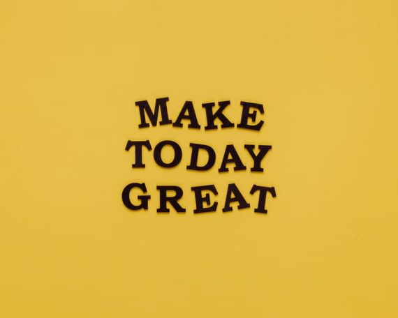 Simple and motivational quote 'Make Today Great' on a minimalist yellow background for inspiration.